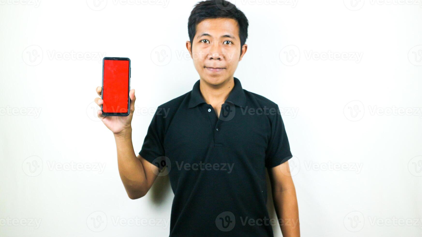 Mobile App Advertisement. Asian Man hold At Green Empty Smartphone Screen Posing Over White Studio Background, Smiling To Camera. Check This Out, Cell Phone Display Mock Up photo