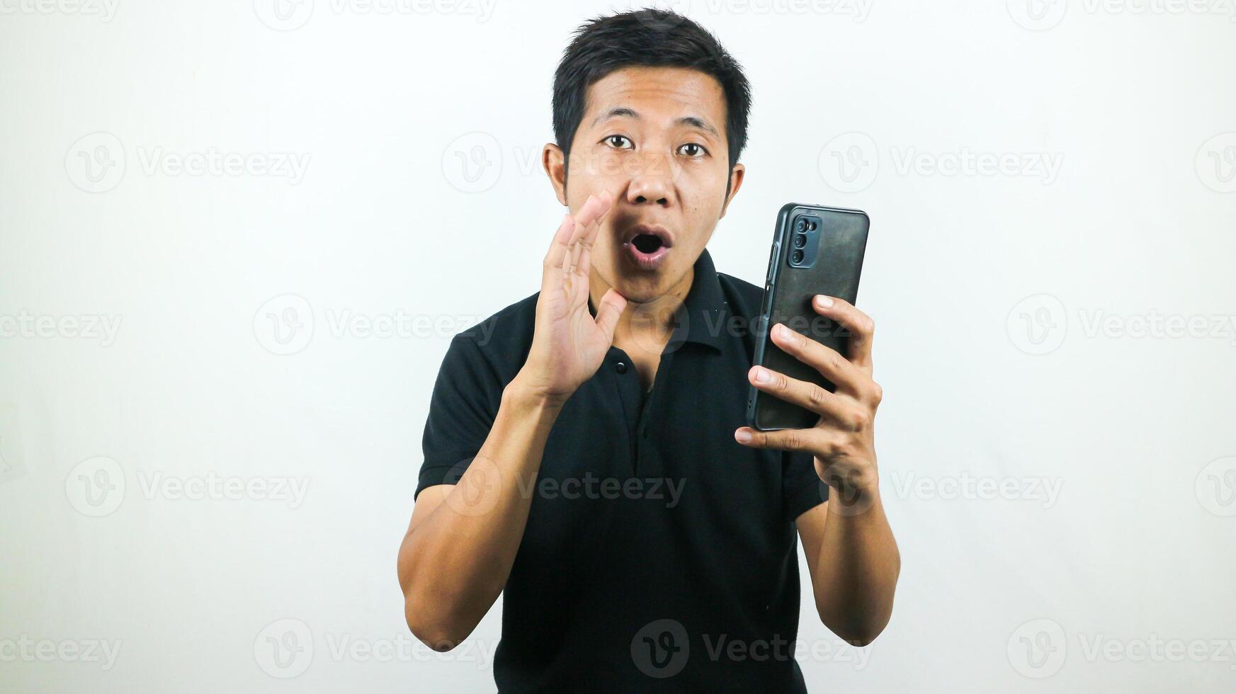 Asian man hold smartphone and whispering some secret gossip isolated on white background. photo