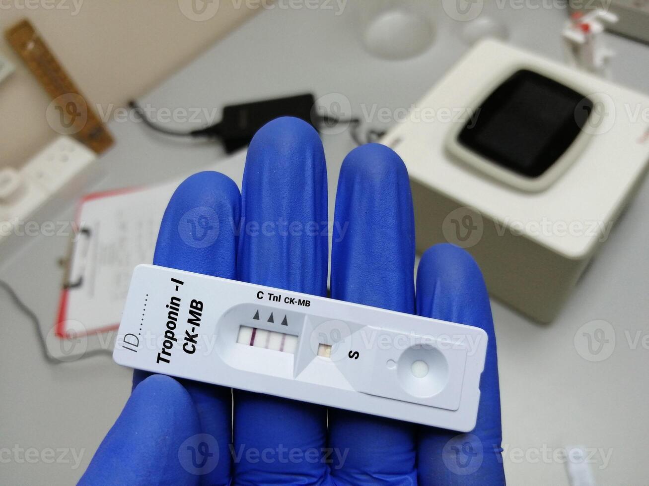 Scientist holding rapid test cassette for Troponin-I and CK-MB test, myocardial infraction. photo