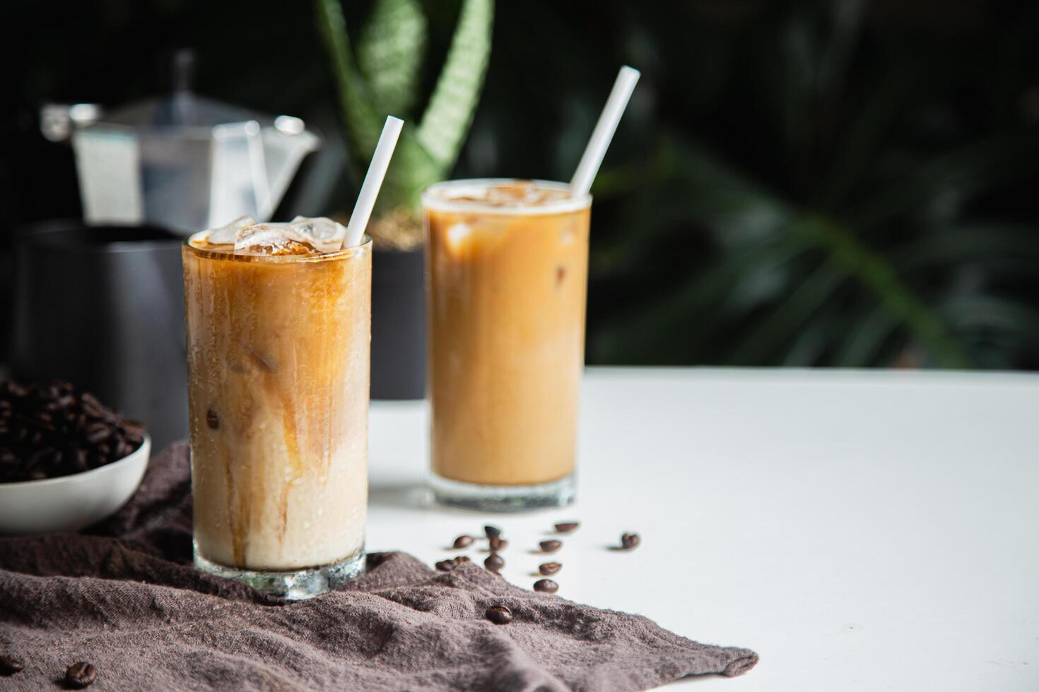 con hielo de café taza en vaso taza y frijoles café , café moka maceta sitio en blanco mesa Copiar espacio para tu texto. foto