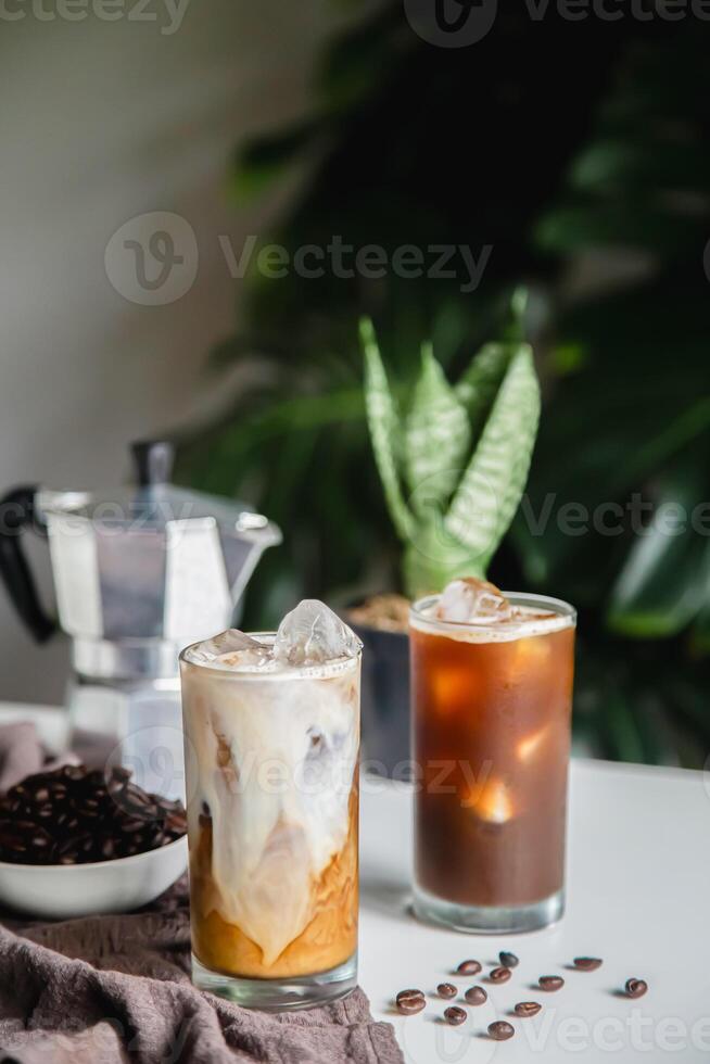 Iced of coffee cup on glass cup and beans coffee , moka coffee pot place on white table copy space foryour text. photo