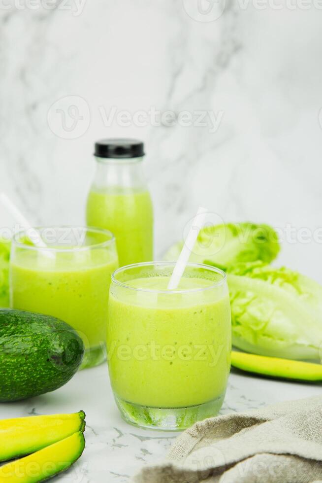aguacate y verde cos ensalada mezclado en un vaso y botella, sano Bebiendo agua. vertical foto