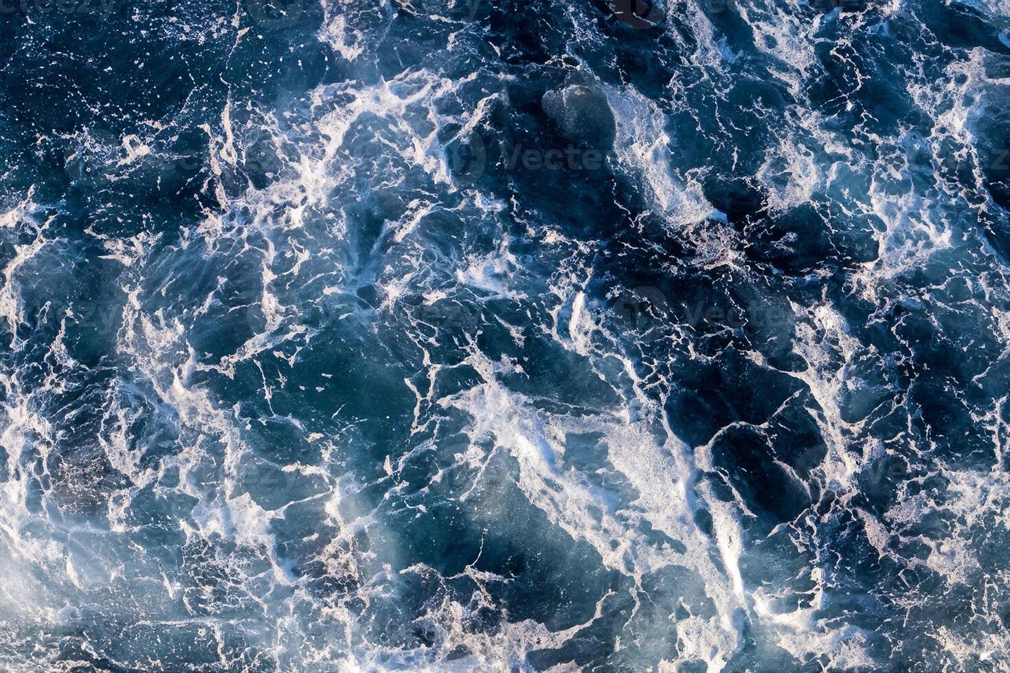 Top down aerial view of sea water surface. White foam waves texture as natural background. photo