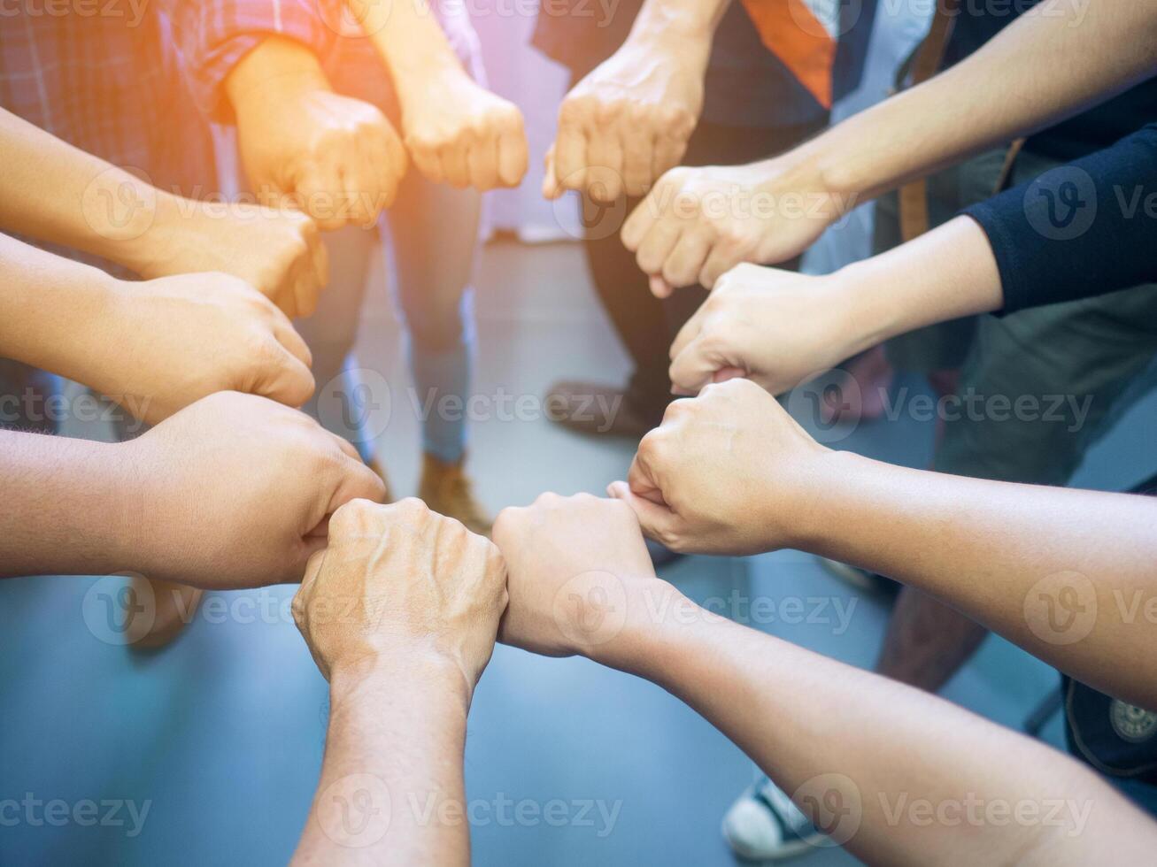 Close-up of many people putting their fists together as a symbol circle of unity. Concept of unity and teamwork. photo