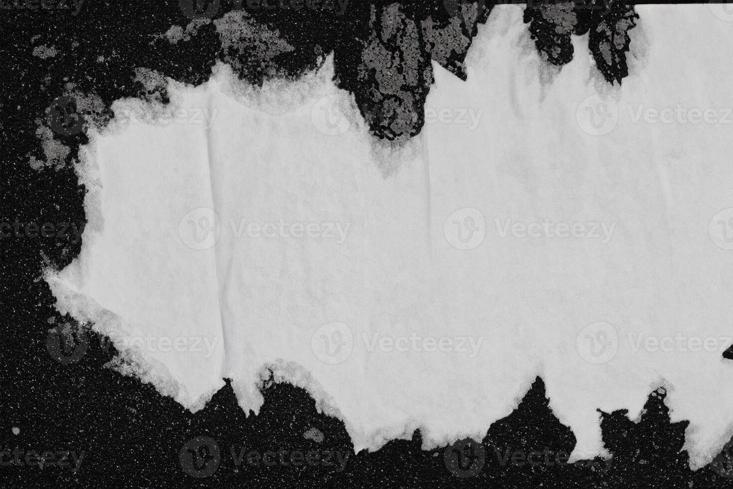 A sheet of white paper pasted on a black wall. photo