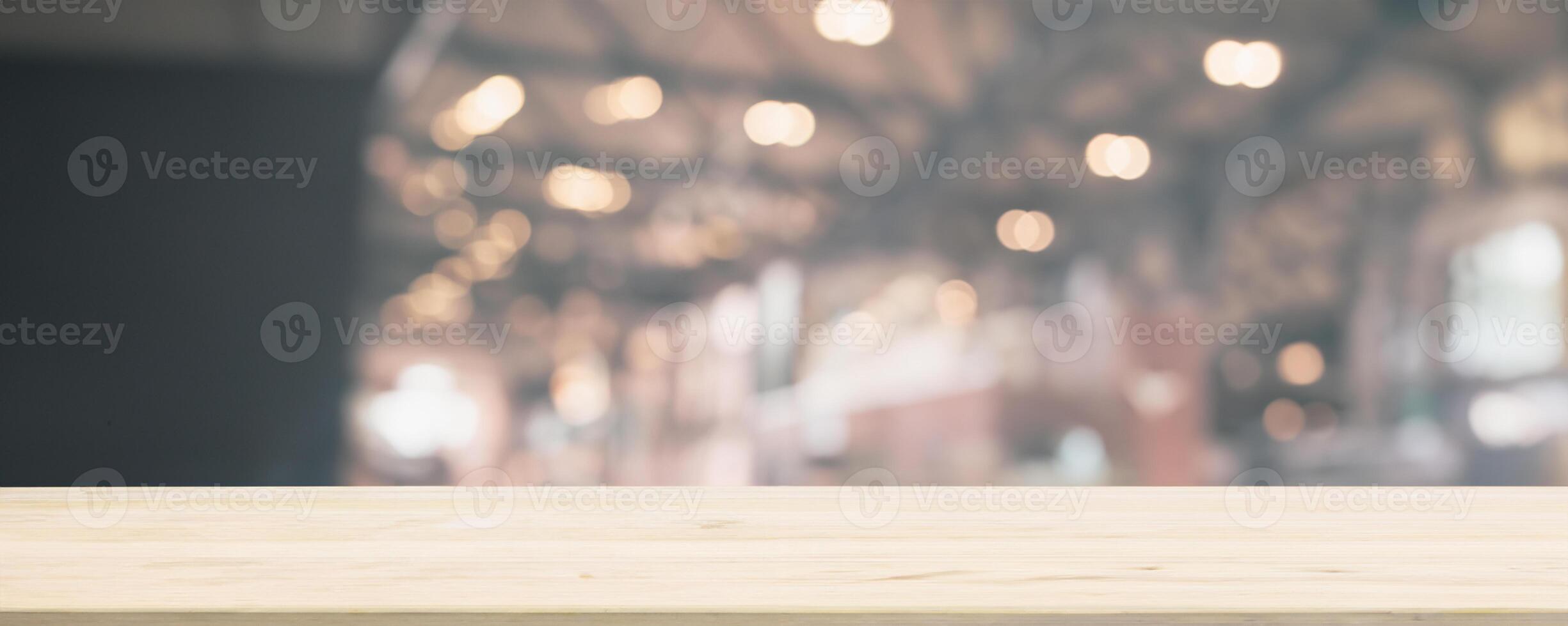 Empty wooden table top with cafe restaurant or coffee shop window interior abstract blur defocused with bokeh light background for montage product display photo