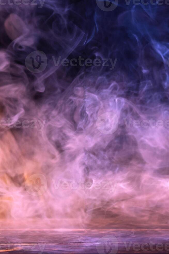 Conceptual image of multi-colored smoke isolated on dark black background and wooden table. photo