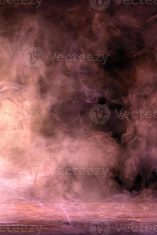 Conceptual image of multi-colored smoke isolated on dark black background and wooden table. photo