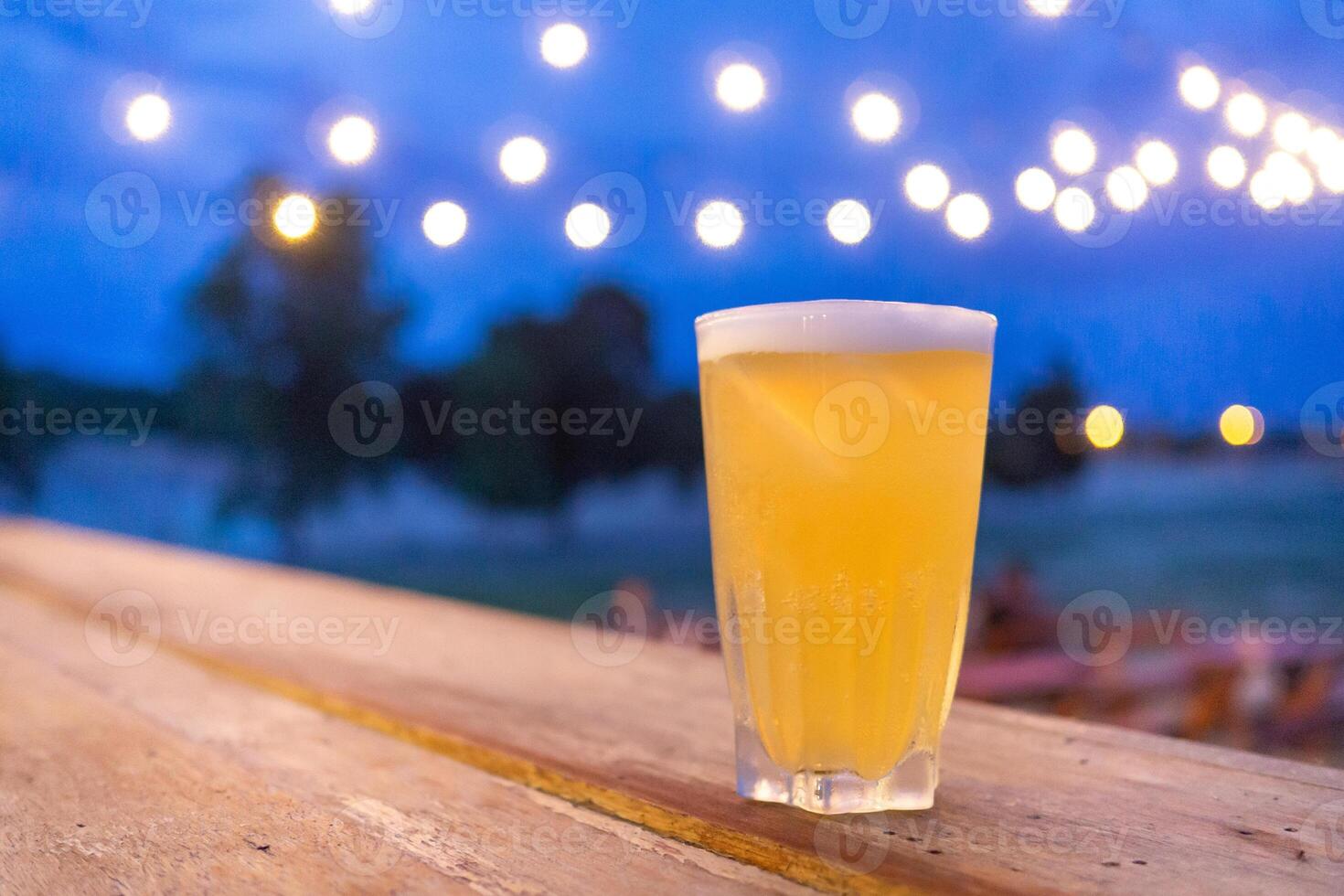Glass of beer placed on a wooden table photo