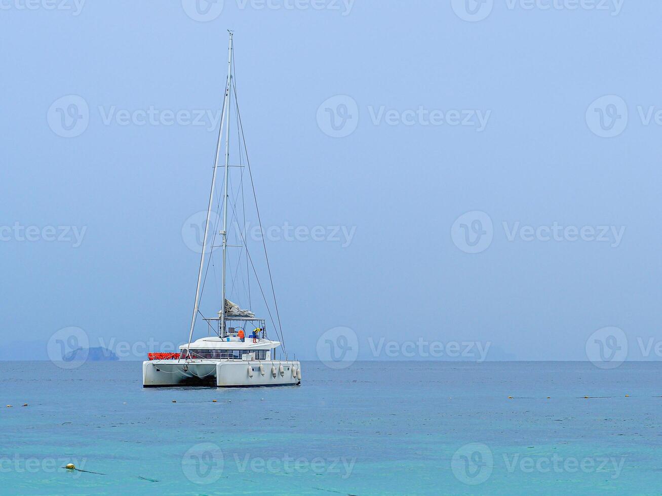 Seascape beautiful of bright blue sea surface with floating white yacht photo