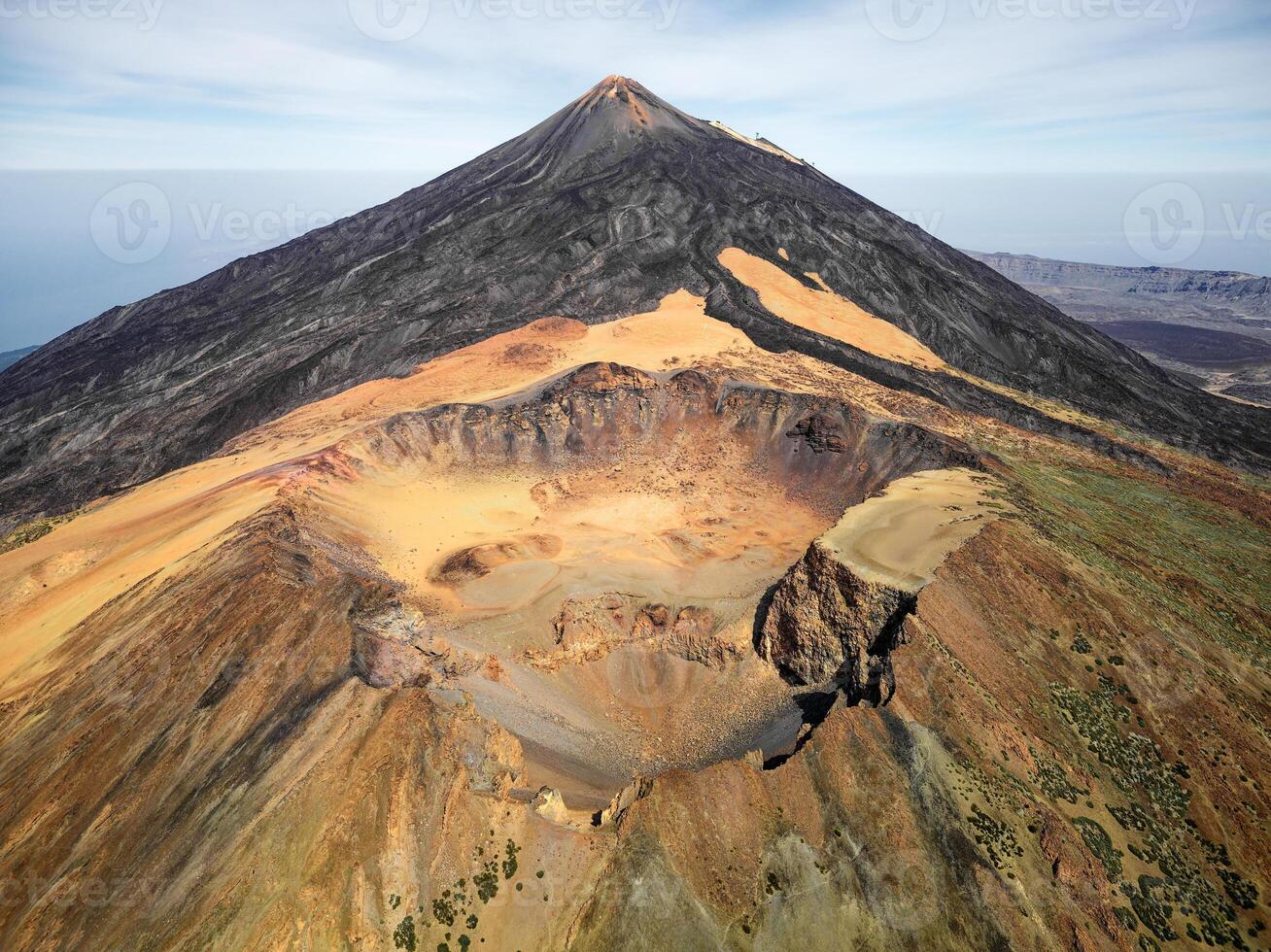 Aerial view of Pico Viejo volcano with Mount Teide in the background in Tenerife, Canary Islands, Spain. Pico Viejo has a spectacular 800 meters diameter crater. Famous destinations for hikers. photo