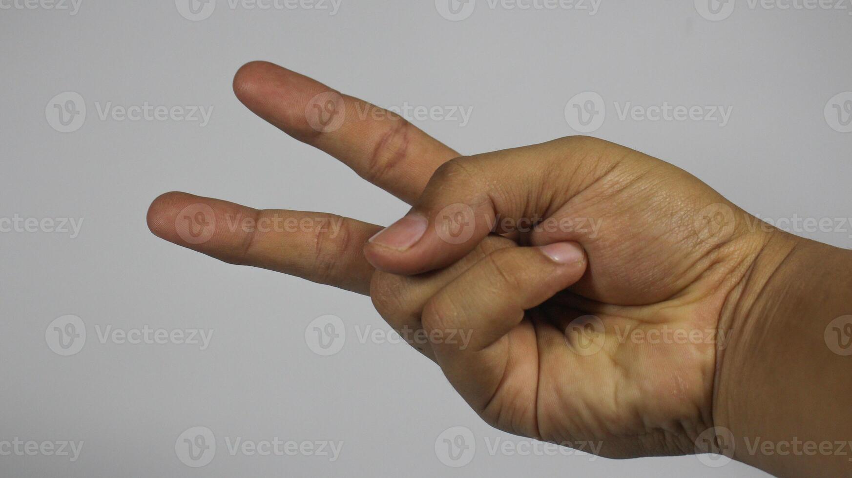 The right hand of a young man gestures with 2 fingers. Isolated on white background photo