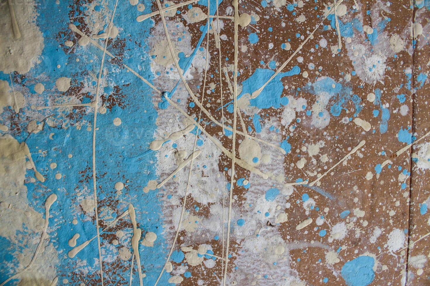 Abstract spots, drops of yellow blue white paint on a brown wooden surface photo