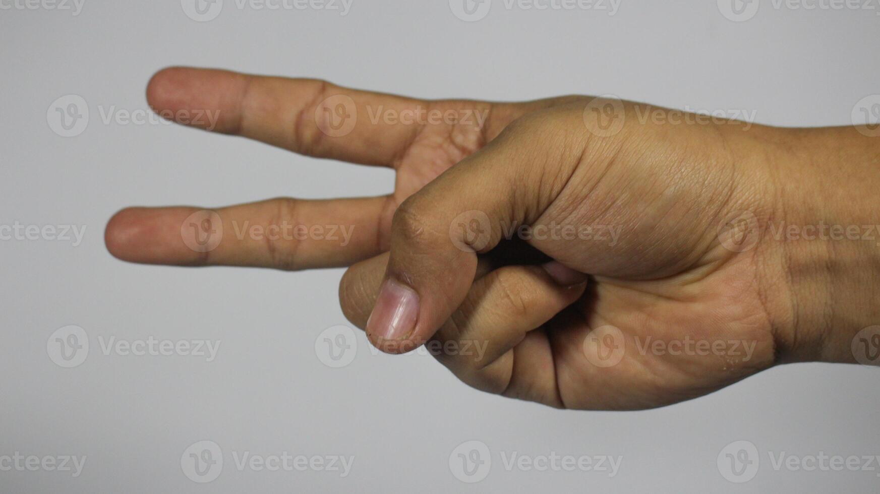 The right hand of a young man gestures with 2 fingers. Isolated on white background photo