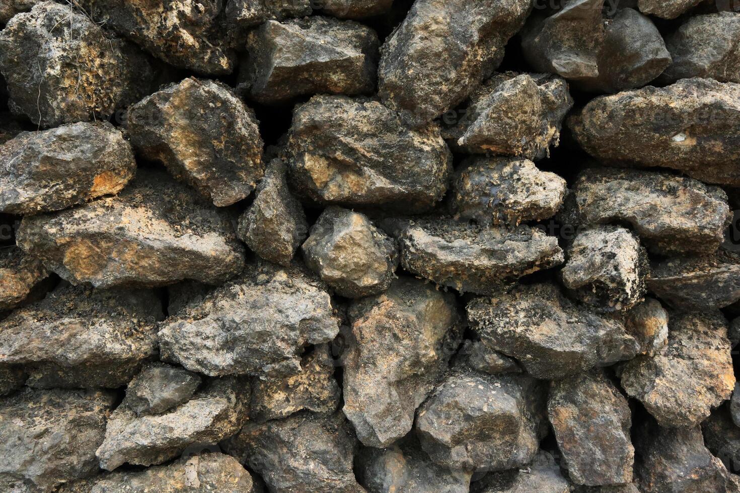 Stacked Rocks Texture, Detailed Texture of A Stone Foundation Supporting Shingle Siding photo