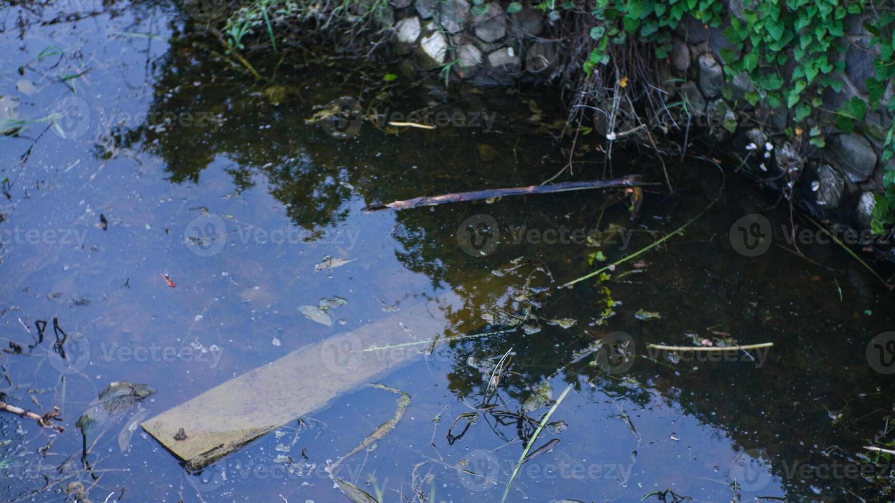 Dirty water in the gutter is filled with rubbish photo