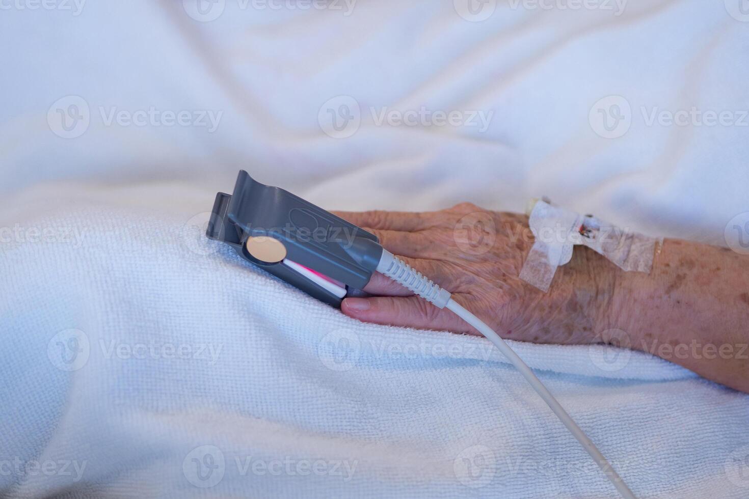 Close-up of blood oxygen oximeter and heart rate from a elderly patient fingertip in room at the hospital. Health care concept photo