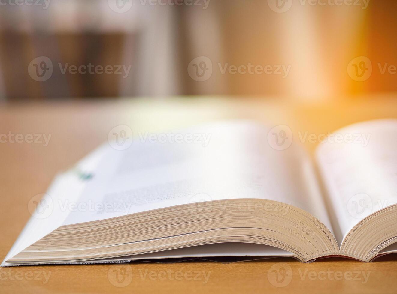 Close-up of book open on desk with sunlight effect blur background. photo