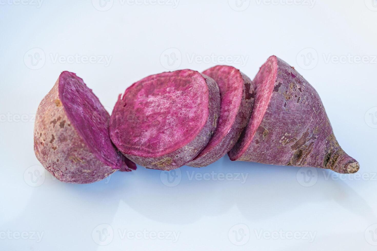 Close-up of fresh purple yams sliced on white background photo
