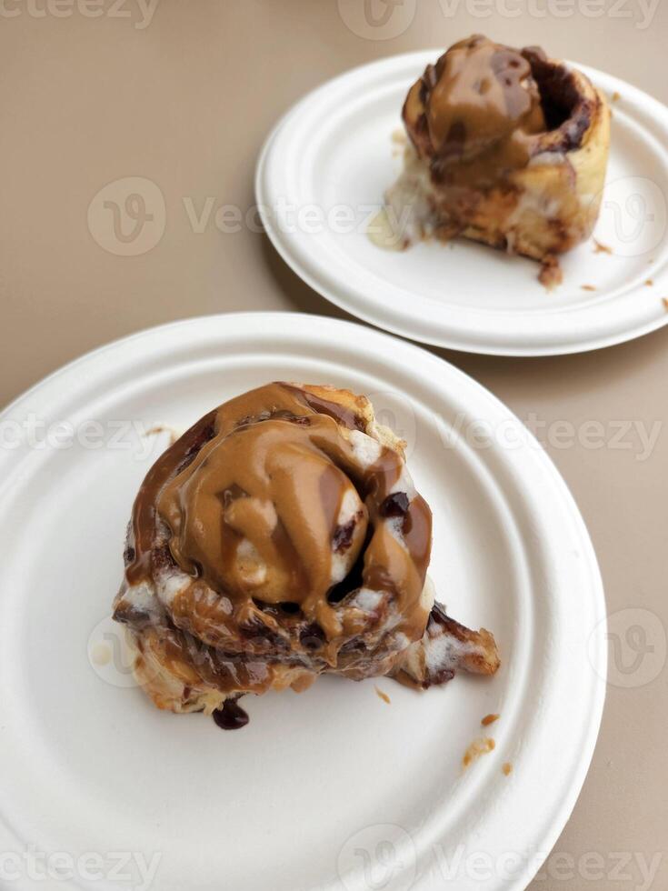 Sweet culinary pastries. Cinnabon in chocolate glaze. Culinary product photo