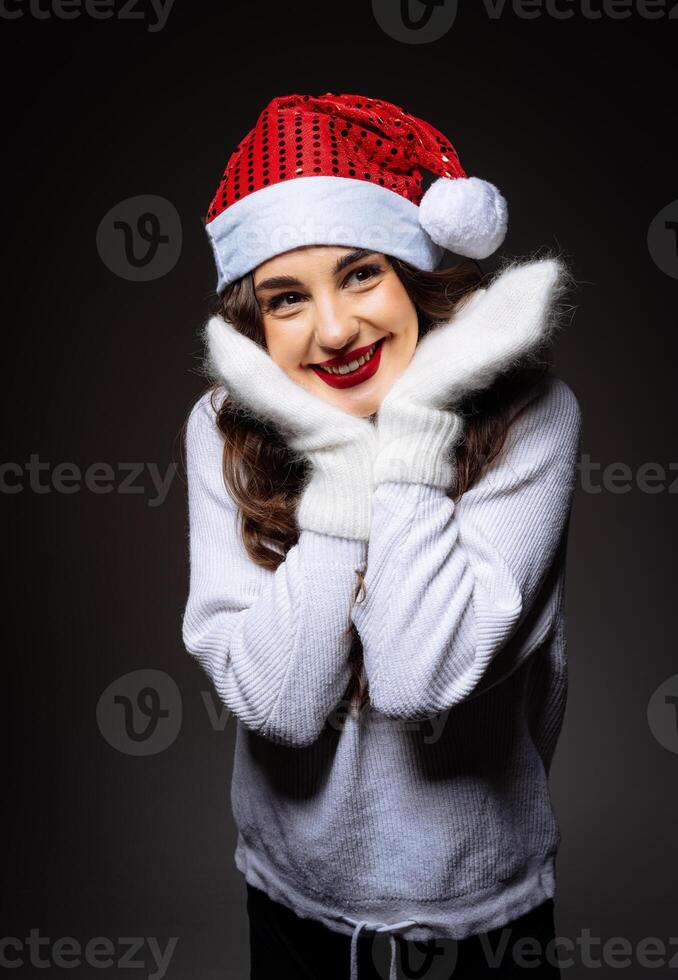 A Woman Wearing a Santa Hat and Scarf photo