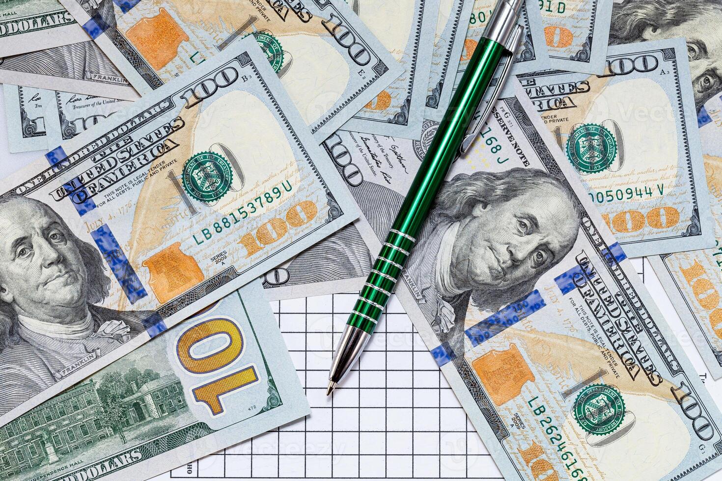 A Precious Pen Resting on a Stack of Cash. A pen sitting on top of a pile of money photo