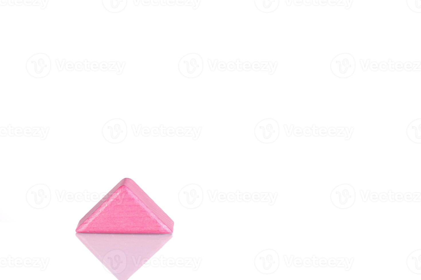 Wooden triangle of pink color on a white background photo