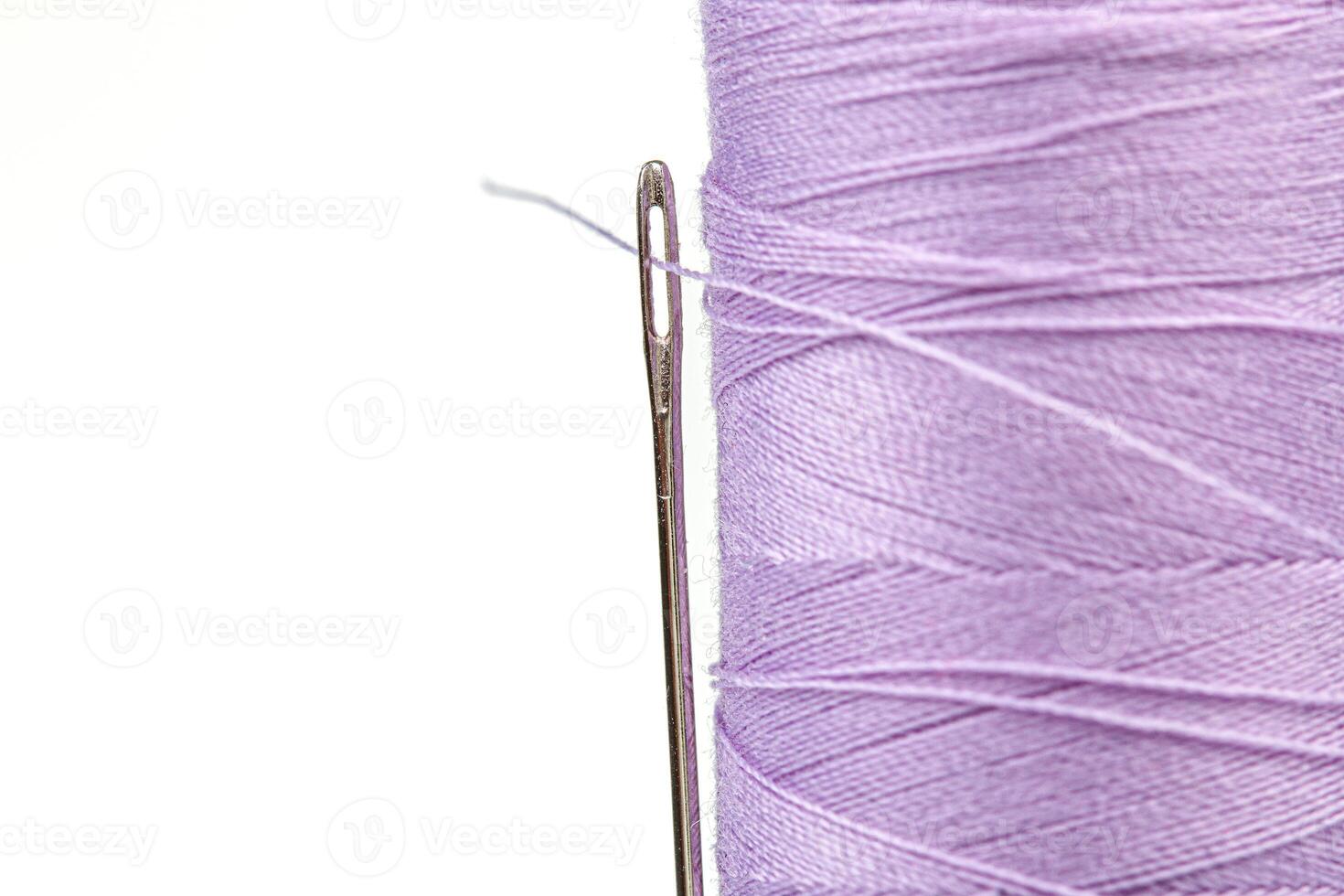 Macro skein of thread purple colors with a needle on a white background photo