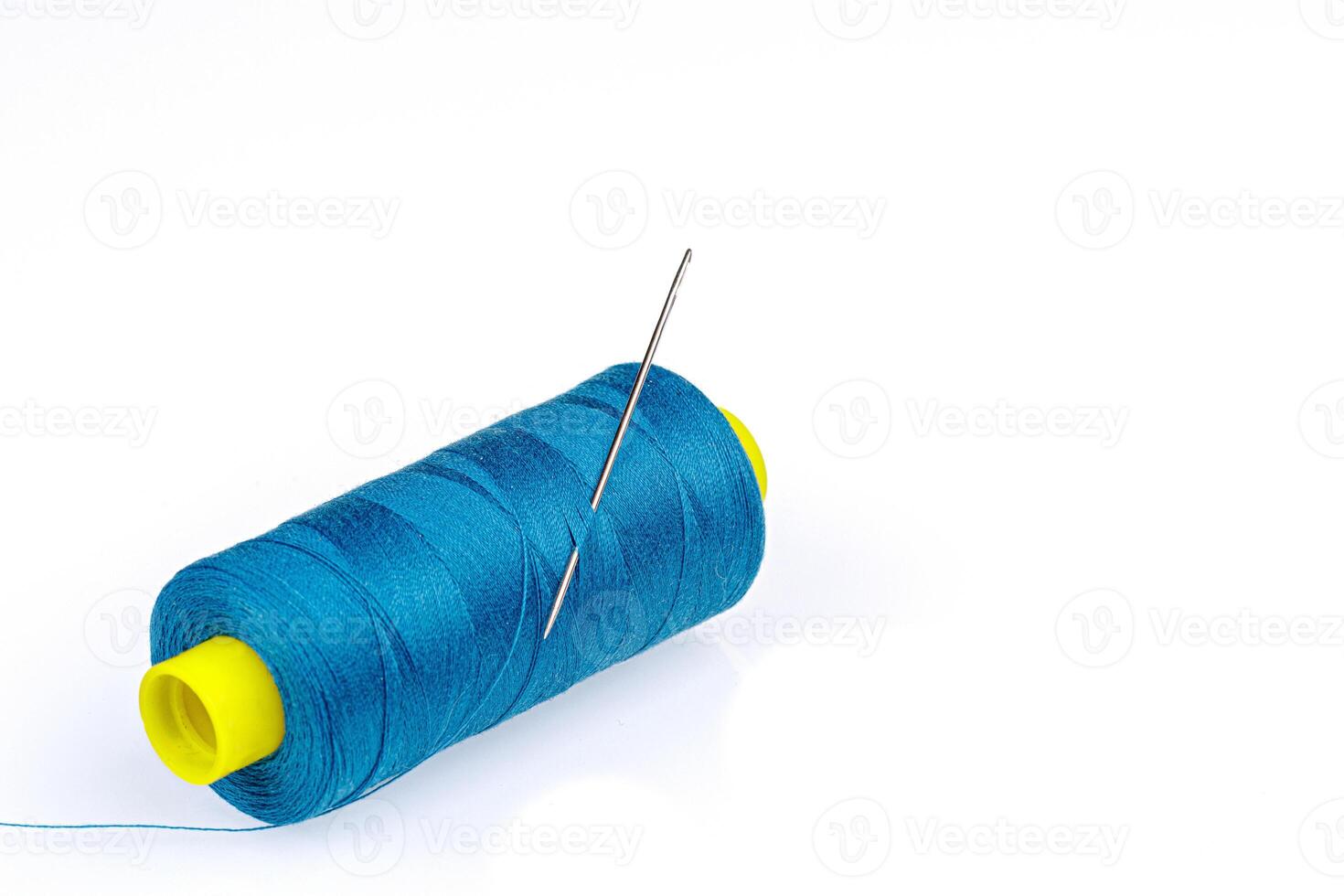Macro skein of blue thread with a needle on a white background photo