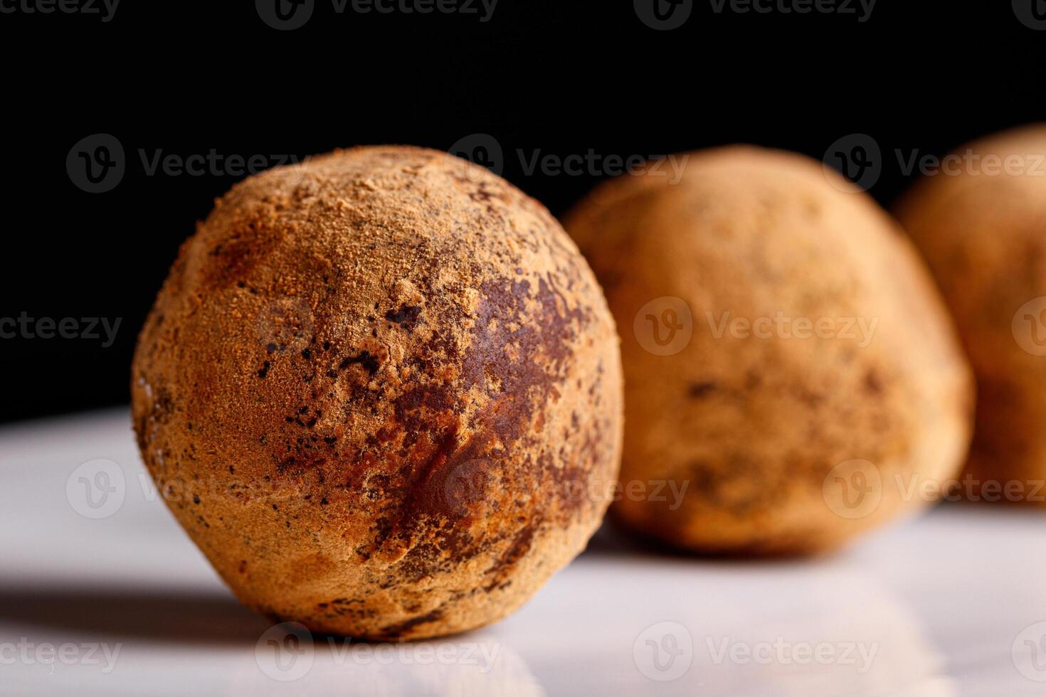 Beautiful candy truffle on a white plate on a black background photo