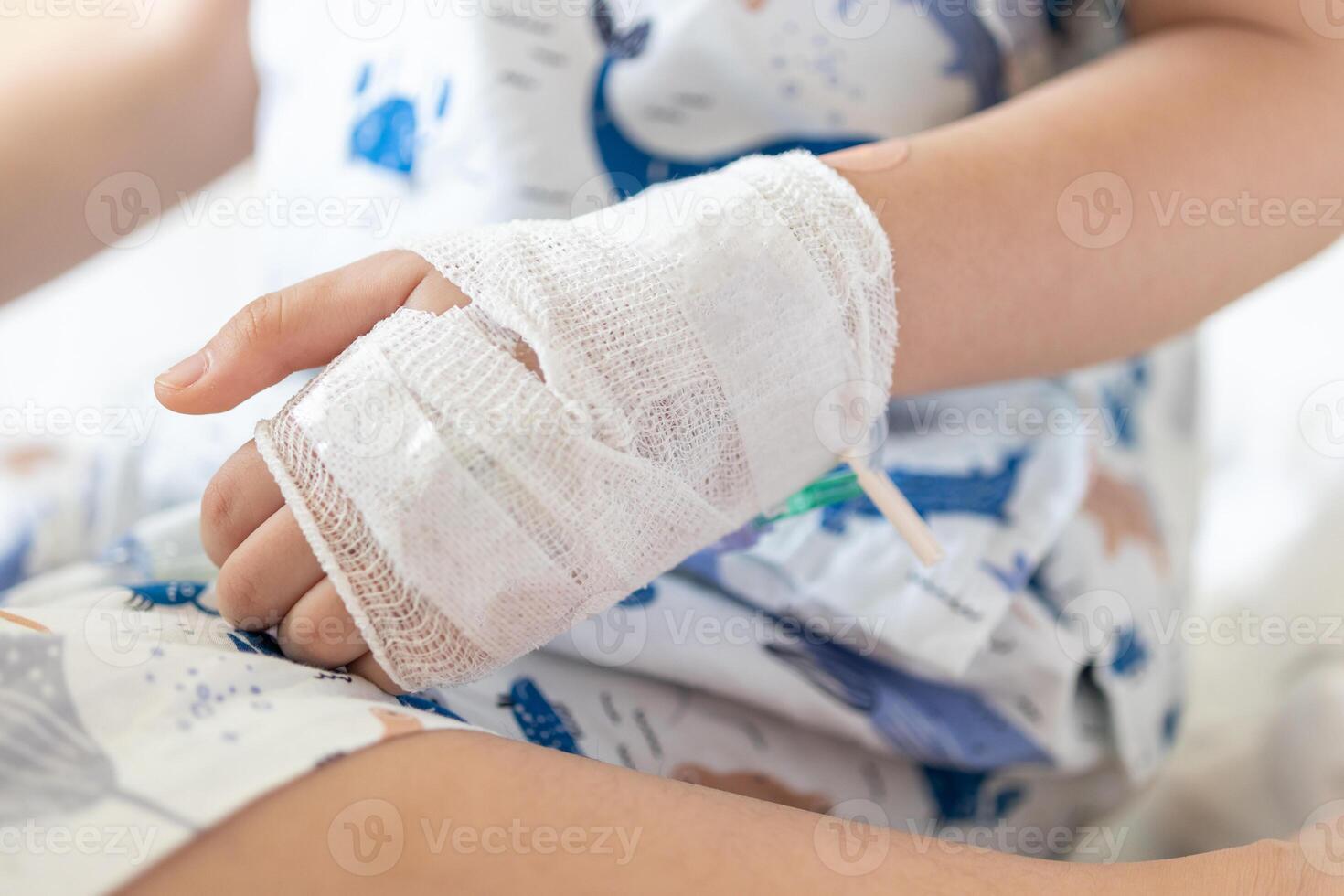 cerca arriba niño mano con salina iv solución en hospital foto