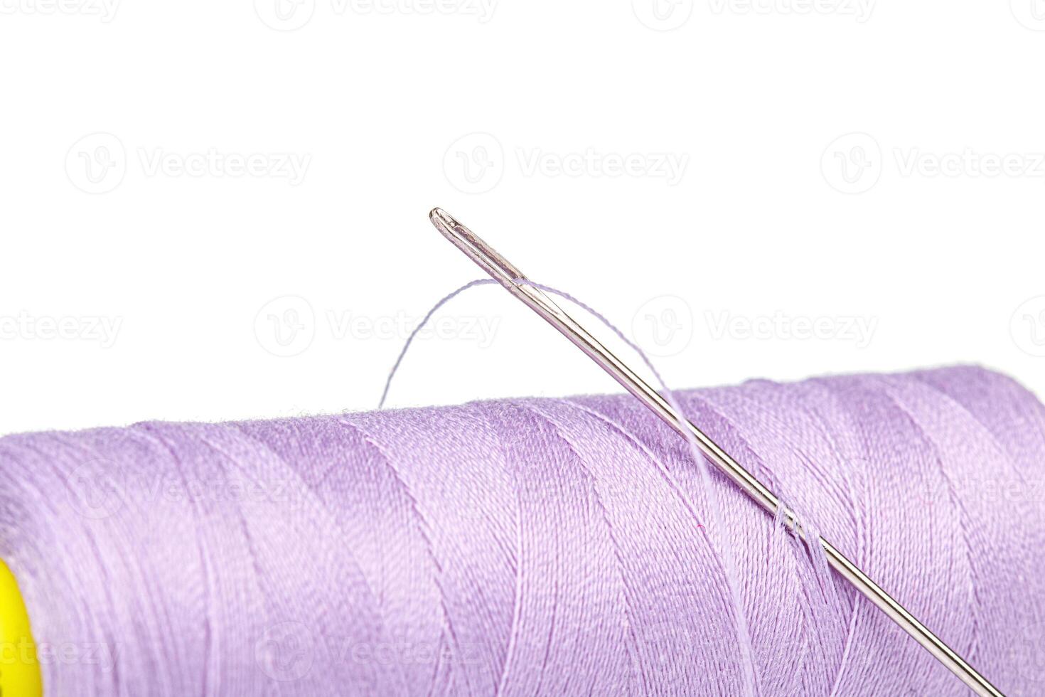 Macro skein of thread purple colors with a needle on a white background photo