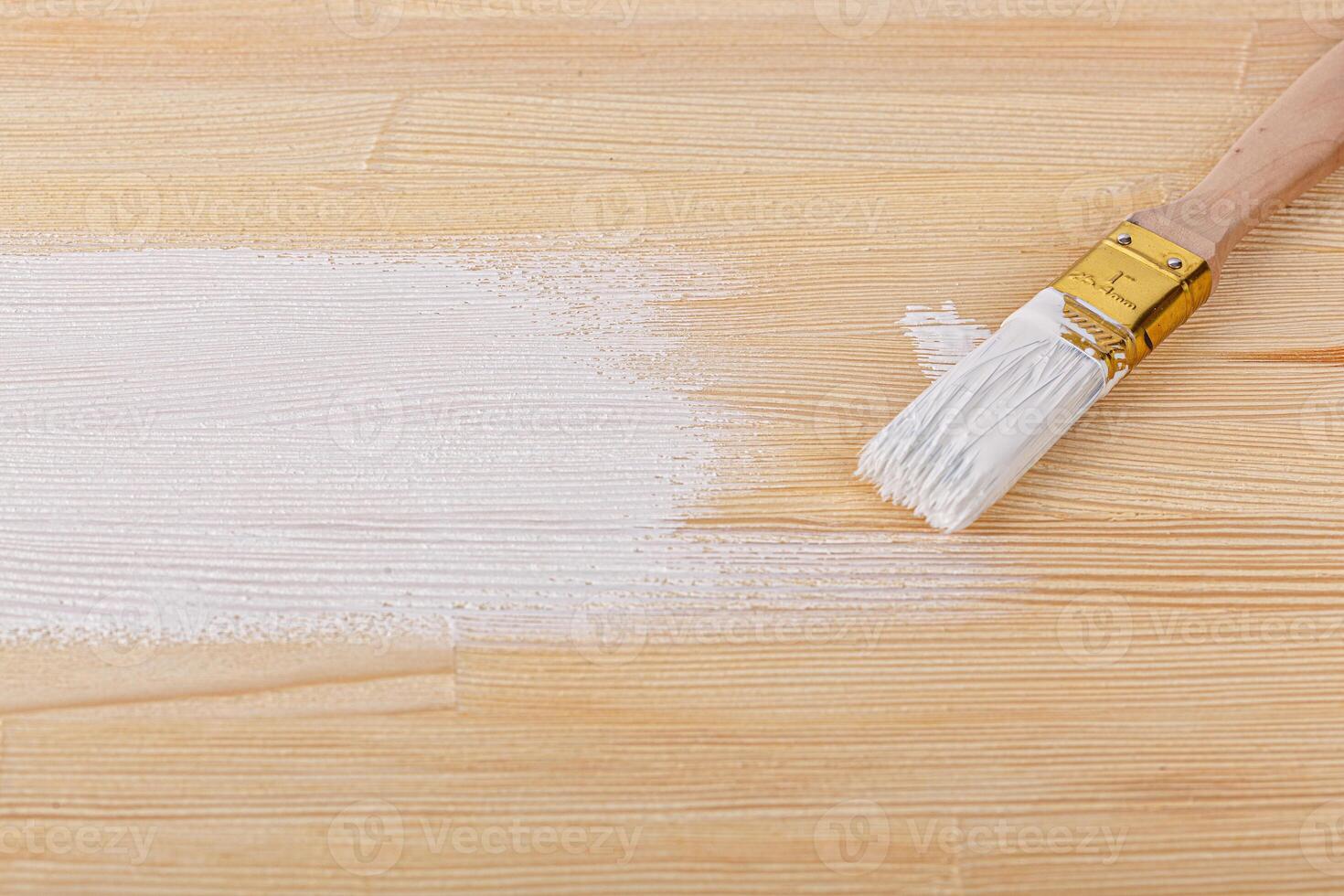 white paint with a brush on a wooden background with texture photo