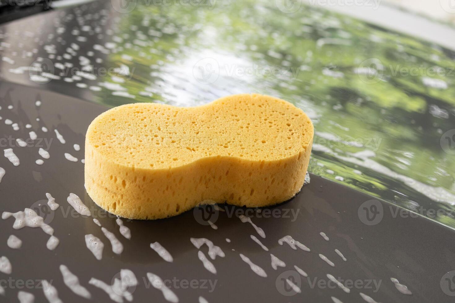 car cleaning and washing with yellow sponge and foam soap photo