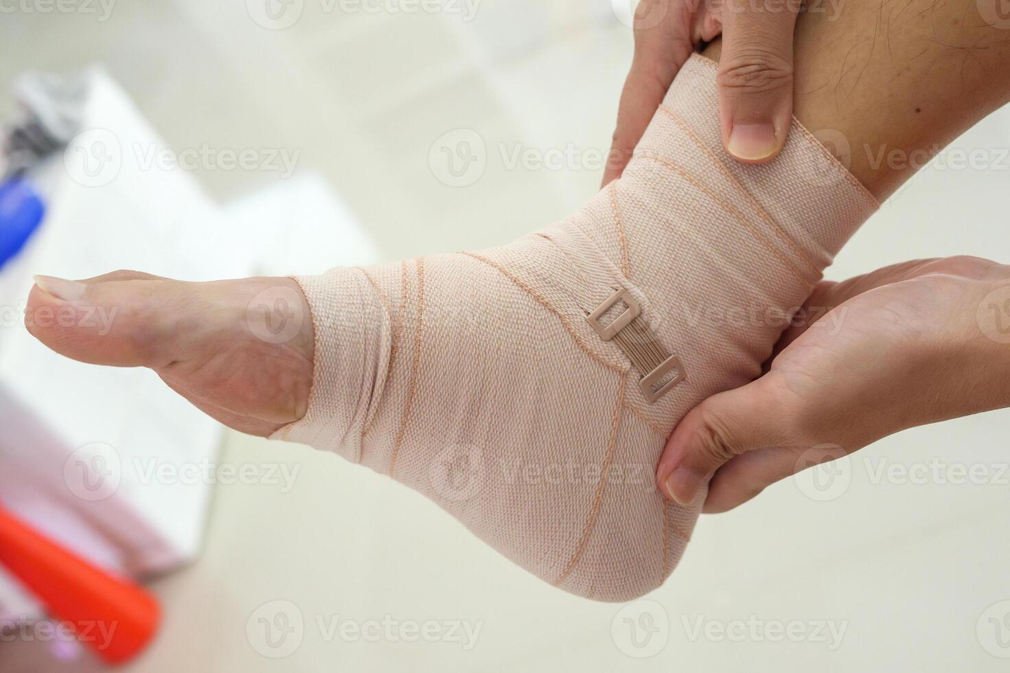 Man with ankle sprain elastic bandage for ankle injury and feeling pain photo