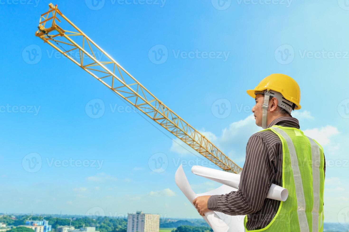 construcción ingeniero trabajador en protector casco y planos papel en mano a edificio sitio antecedentes foto