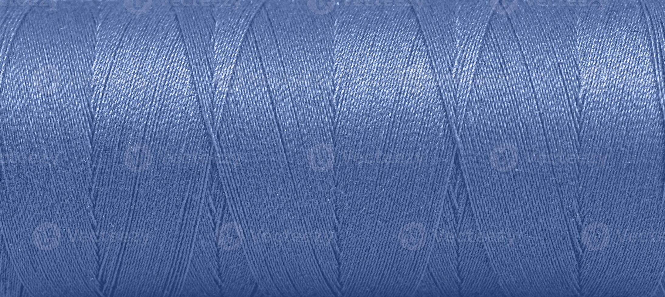 Texture of threads in a spool of blue color on a white background photo