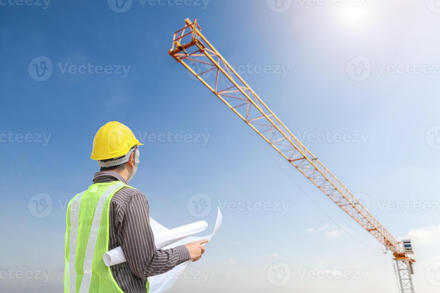 construcción ingeniero trabajador en protector casco y planos papel en mano a edificio sitio antecedentes foto