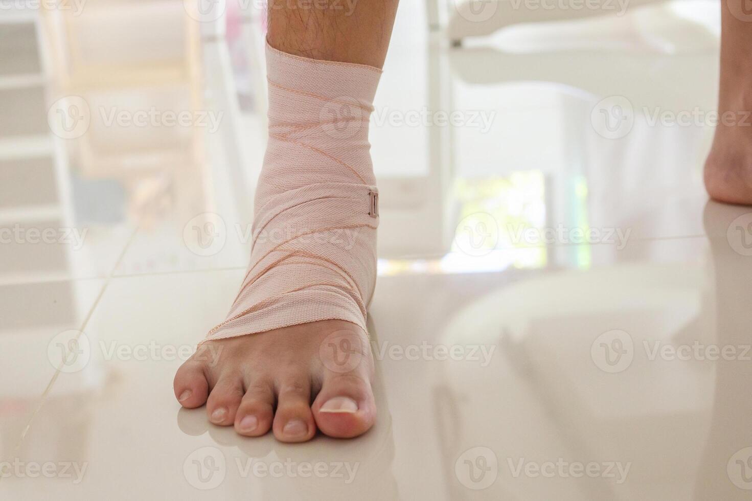 Man with ankle sprain elastic bandage for ankle injury and feeling pain photo