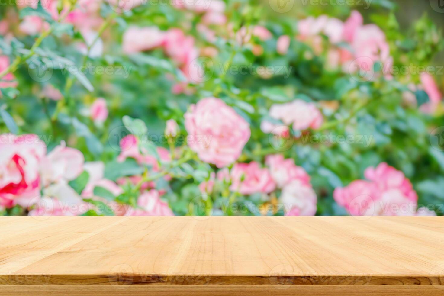 Empty wood table top with blur rose garden background for product display photo