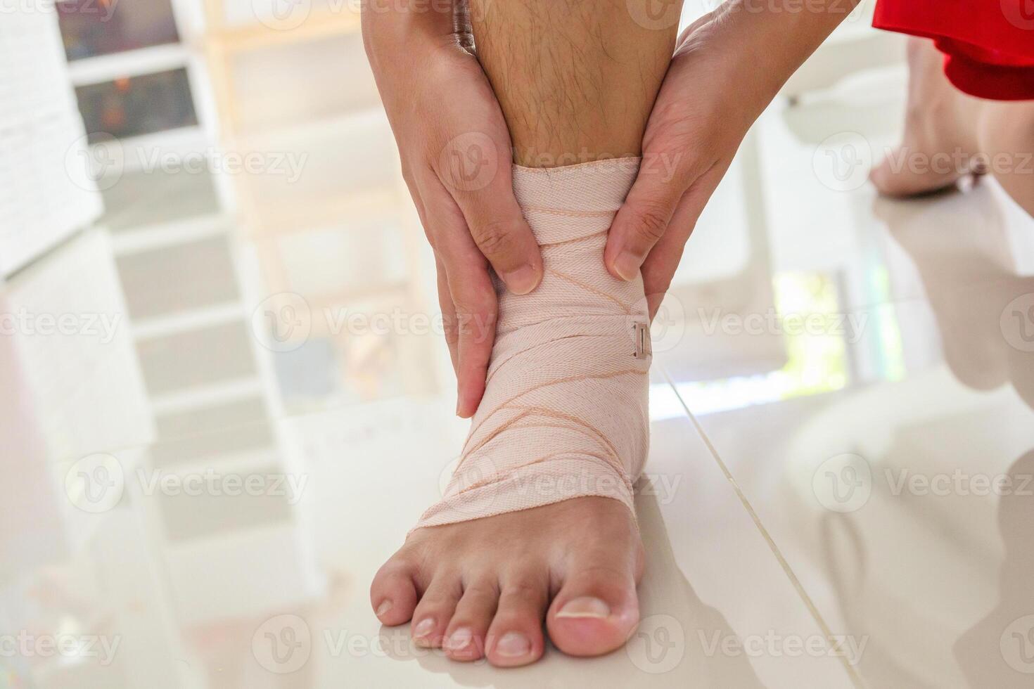 Man with ankle sprain elastic bandage for ankle injury and feeling pain photo