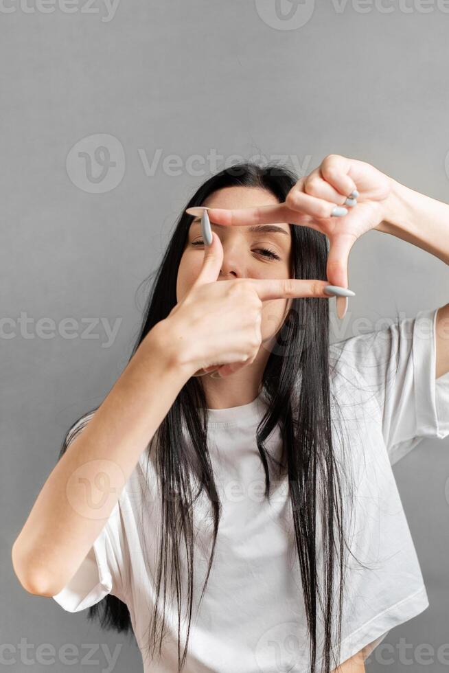 joven niña muestra el marco con su manos foto