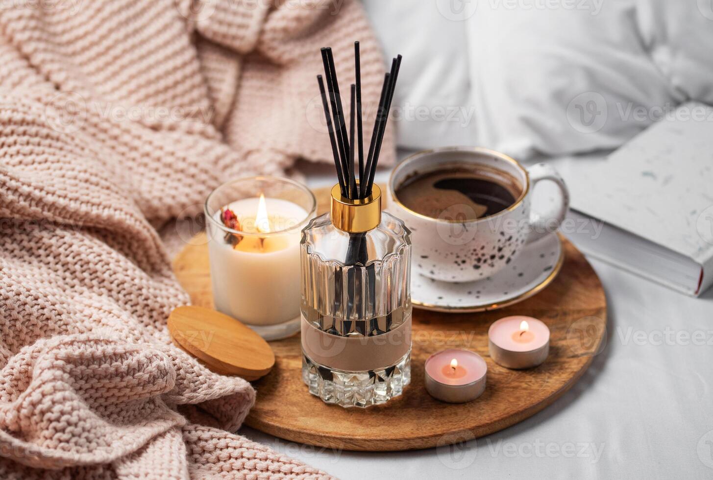 Bamboo sticks in bottle with scented candles and cup of coffee photo