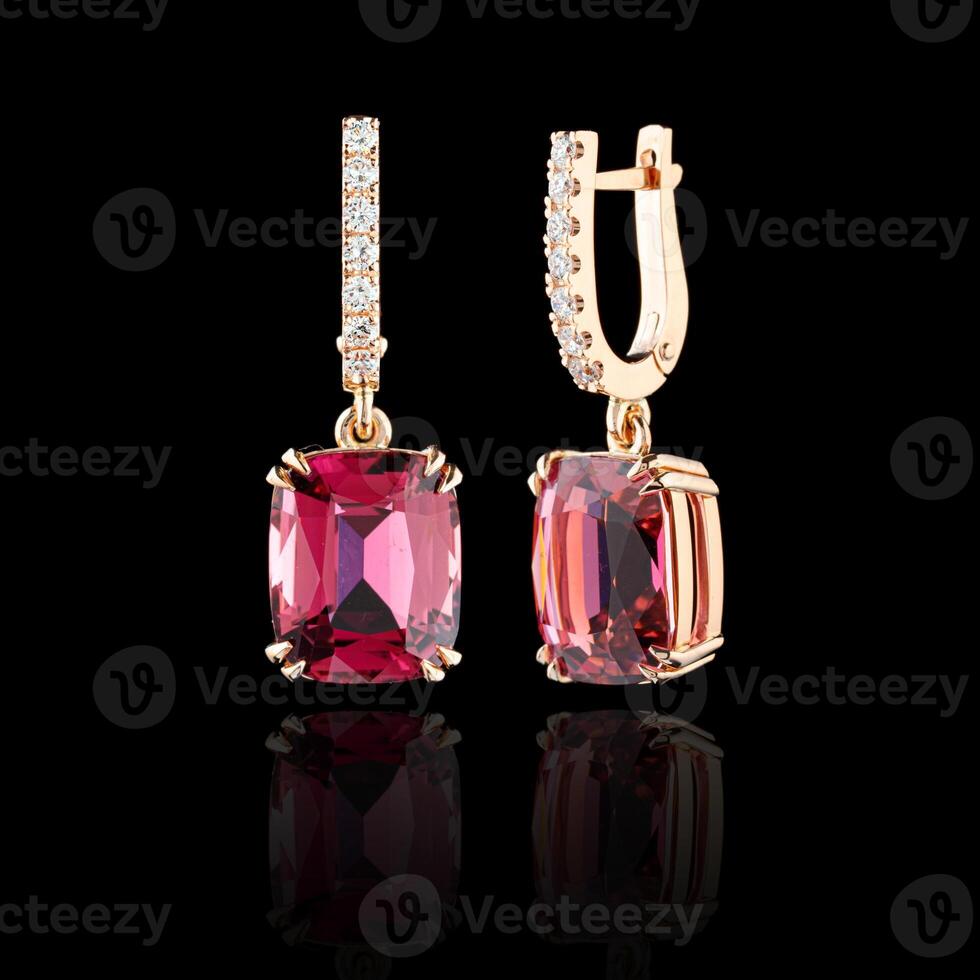 beautiful gold earrings with tourmaline and diamonds on a black background photo