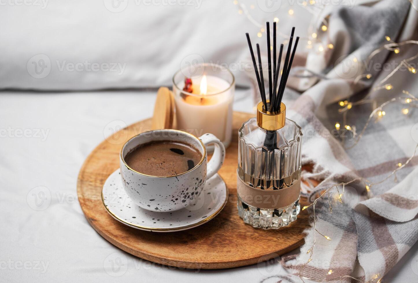 Bamboo sticks in bottle with scented candles and cup of coffee photo