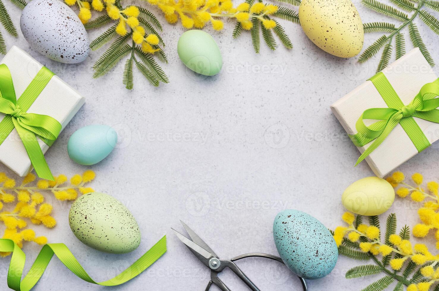 Mimosa branch, Easter eggs and gift boxes on gray concrete background. photo