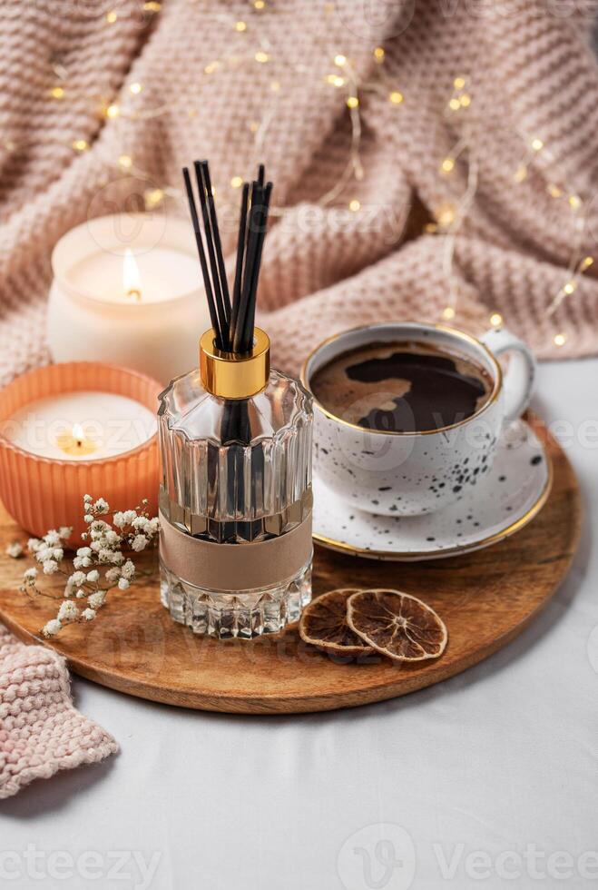 Bamboo sticks in bottle with scented candles and cup of coffee photo