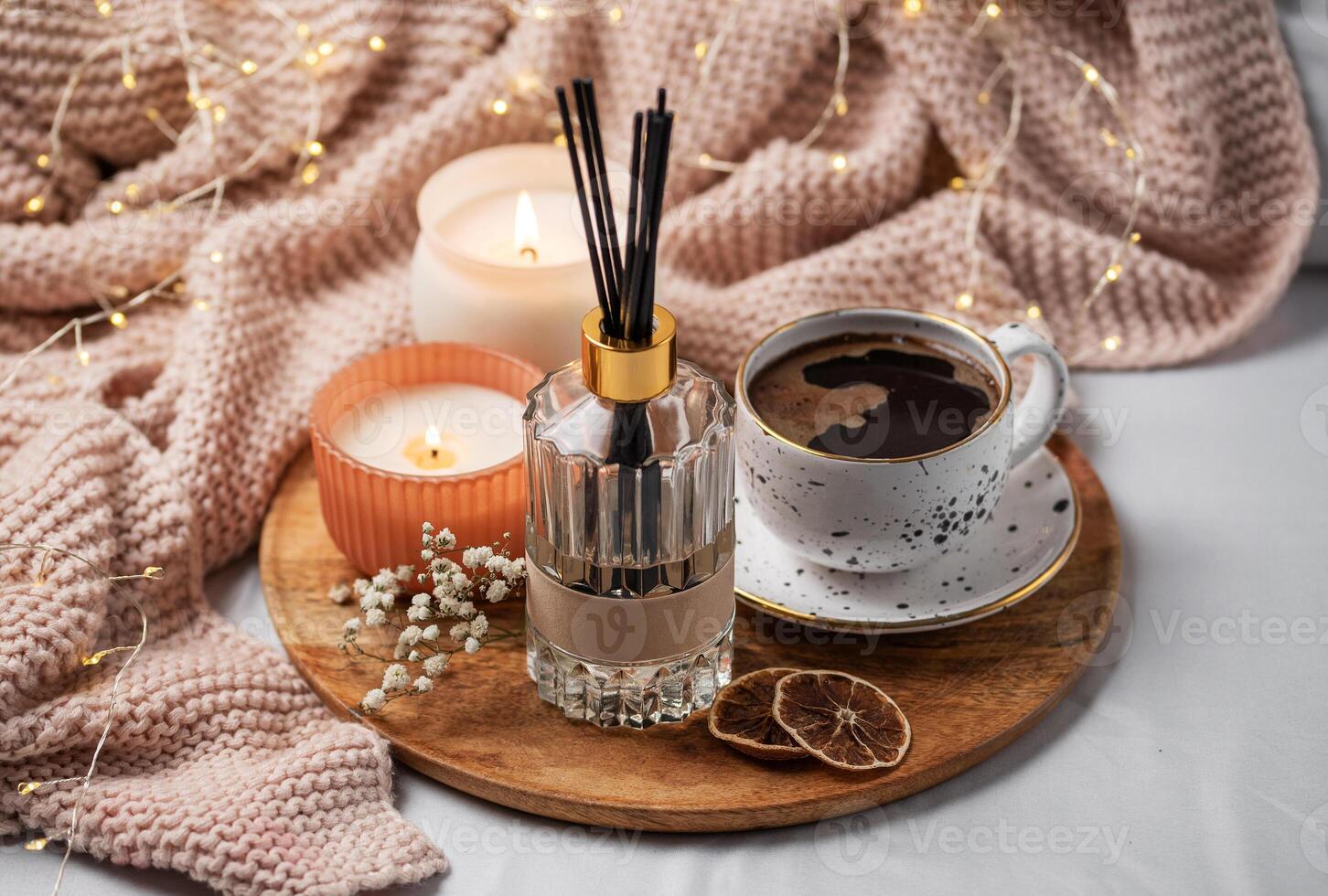 Bamboo sticks in bottle with scented candles and cup of coffee photo