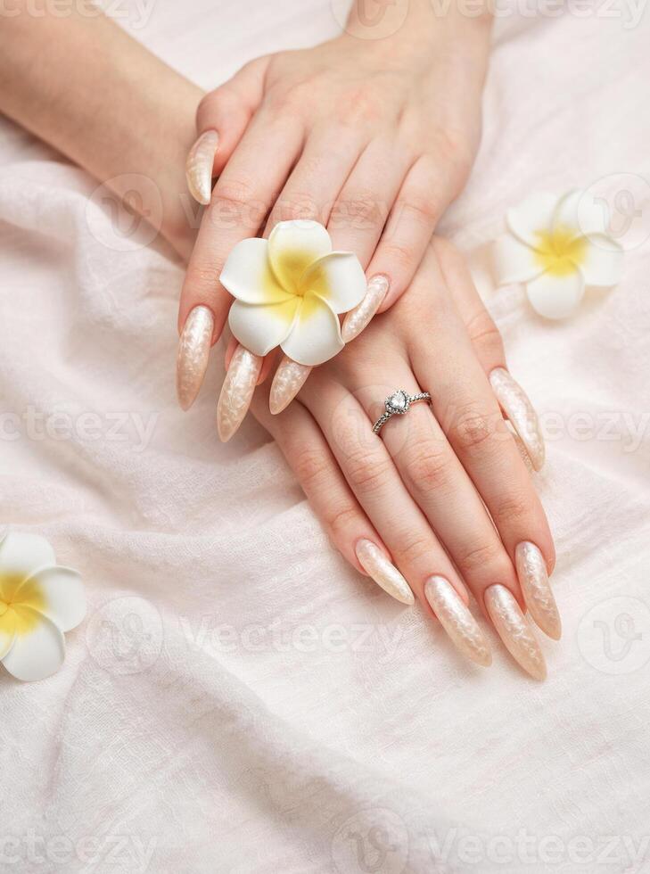 Hand of a young woman with white pearl  manicure photo