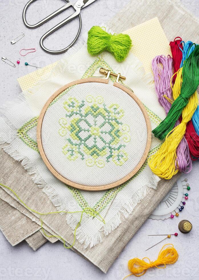 Embroidery with colored threads and various sewing accessories photo